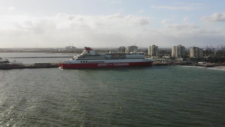 A ferry boat is docked at the city pier on a sunny day