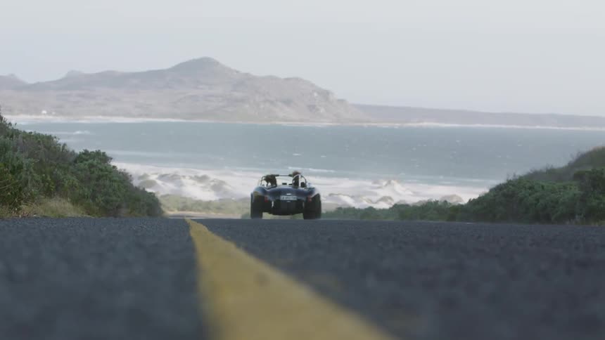 A car drives on the coastal road