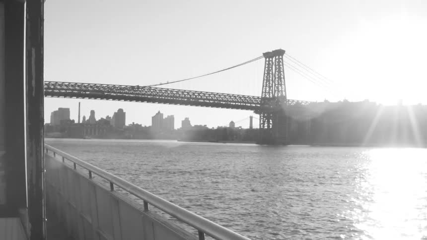 Boating down a river beside a city almost to a bridge