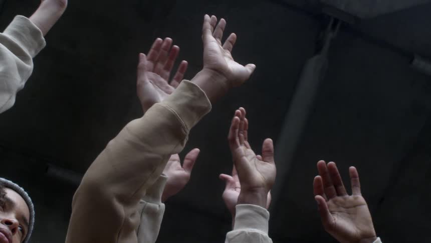 Several hands raised in the air