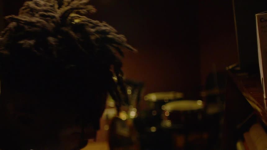 Man moves back and forth in a dimly lit room