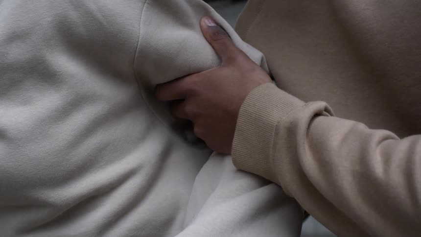 Man squeezes the arm of another person