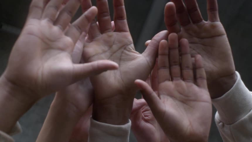 Several hands raised in the air