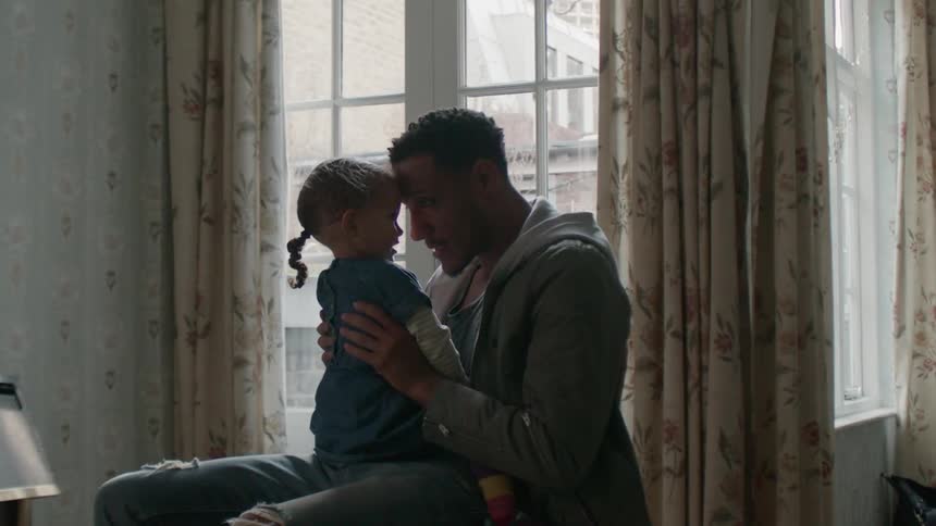 Man holds and talks to a young girl