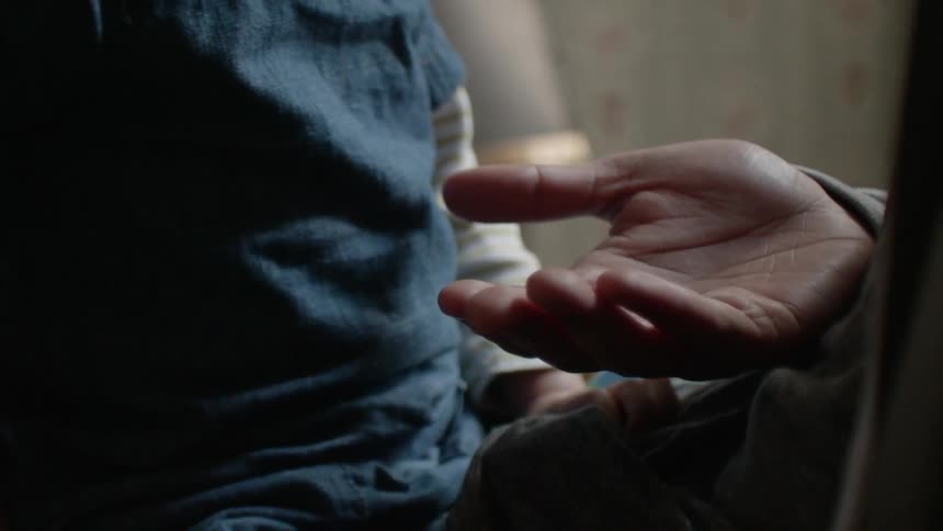Adult holds their hand out and a child pats it