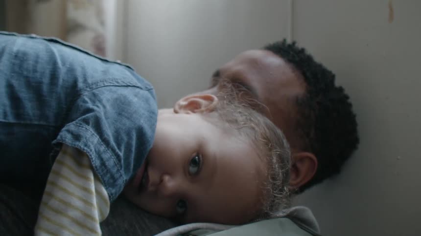 A man holds a young child to his chest