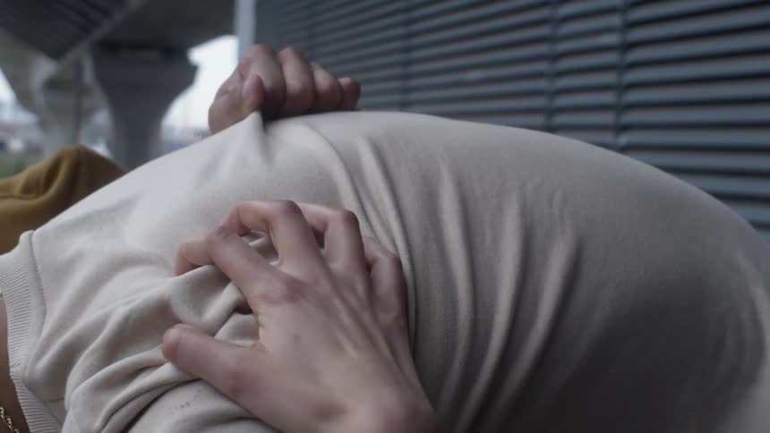 Woman grips a man's shirt while hugging