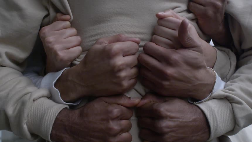 People hug and clench their hands