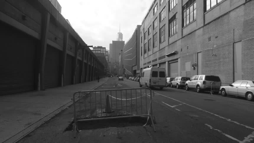 A cordoned off pothole in a city road while cars travel in the other lane