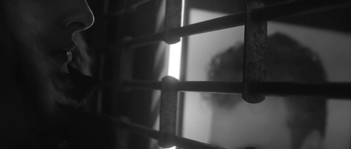 Man looking through a gate into a shop