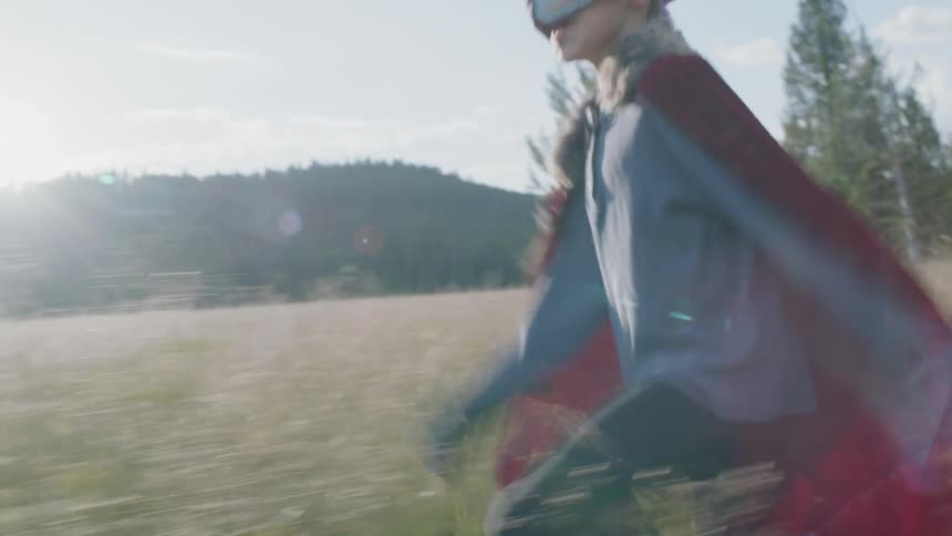 Boy runs through a rural field in a costume