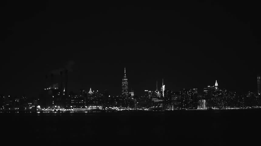 View of a large lit city at night over a body of water