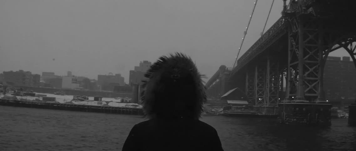 Person looking out at a lake on a cloudy day