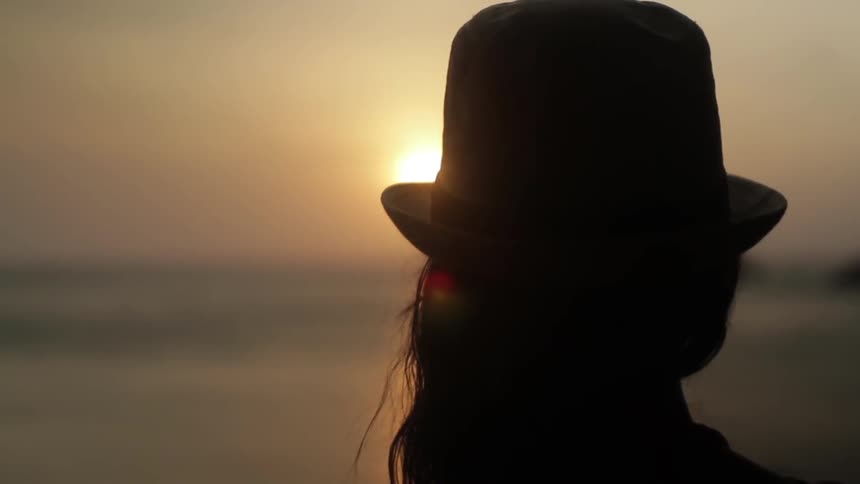 A person wearing a hat watched the sun set