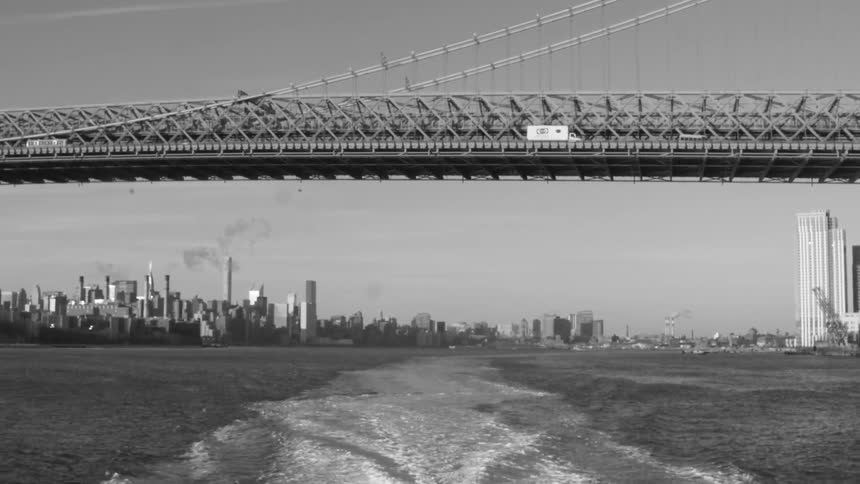 View from a moving boat of a bridge with cars traveling