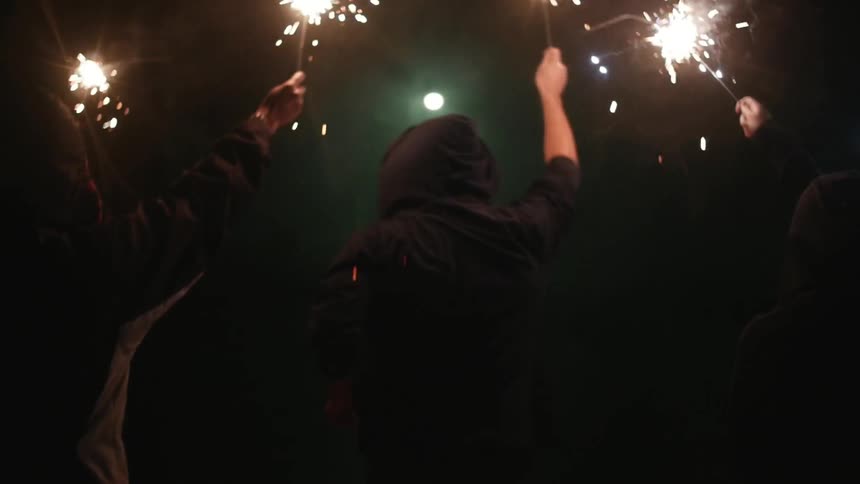 A group of people holding burning sparklers
