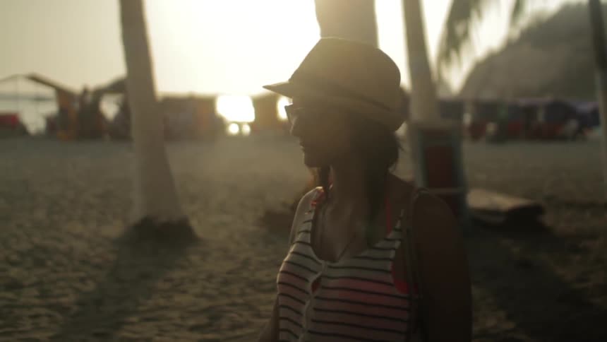 Woman walking on the beach with other people in the background