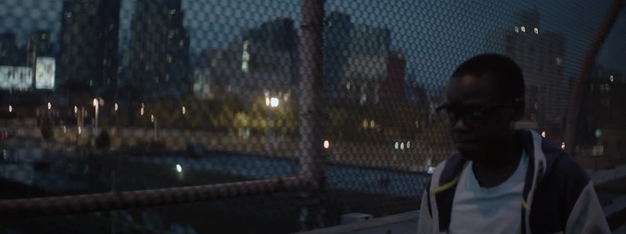 A person walking past a chain link fence