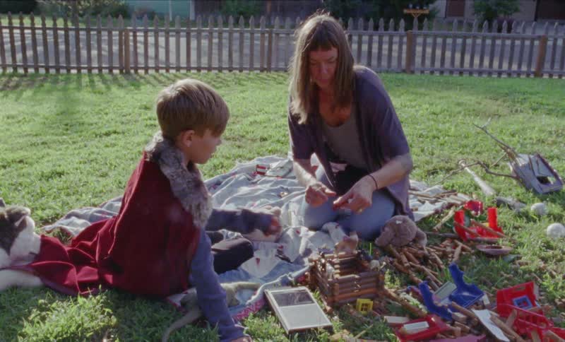 A child and parent play in the yard on the grass