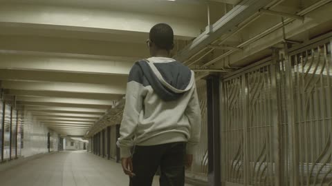 A young man walks through an empty subway station