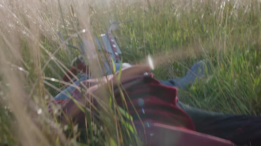 Boy in a costume lies in a rural field
