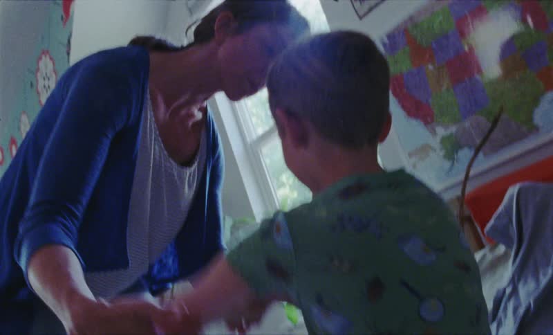 Woman talks to a young boy near a window