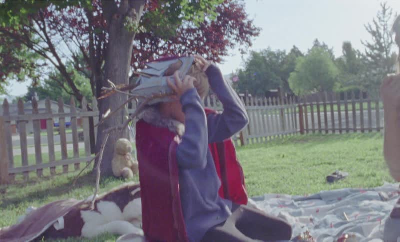 Woman puts a mask on a child's head in the backyard