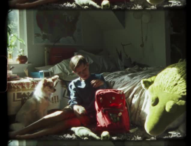 Child takes a glove out of his backpack in his bedroom
