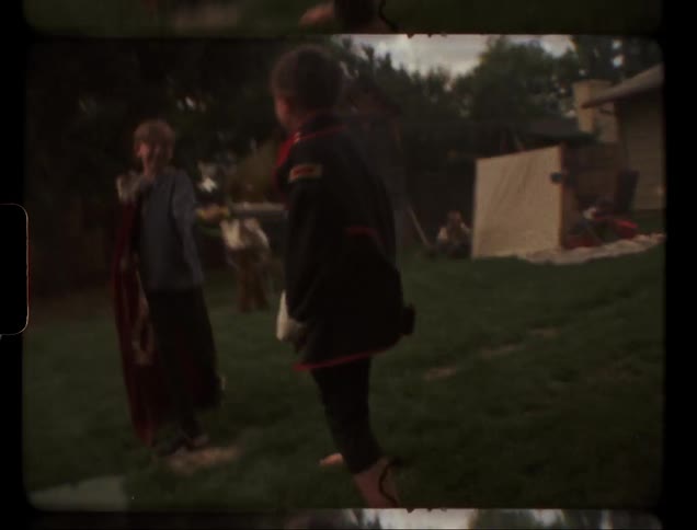 Children play fight in the backyard at sunset