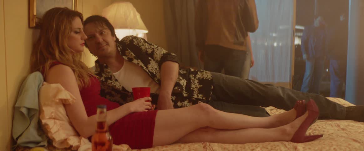 A woman lays on a bed at a party