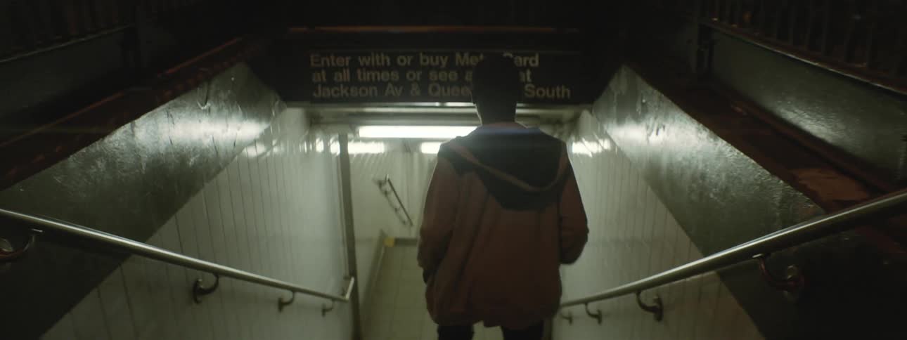 Person walking down stairs leading to a subway