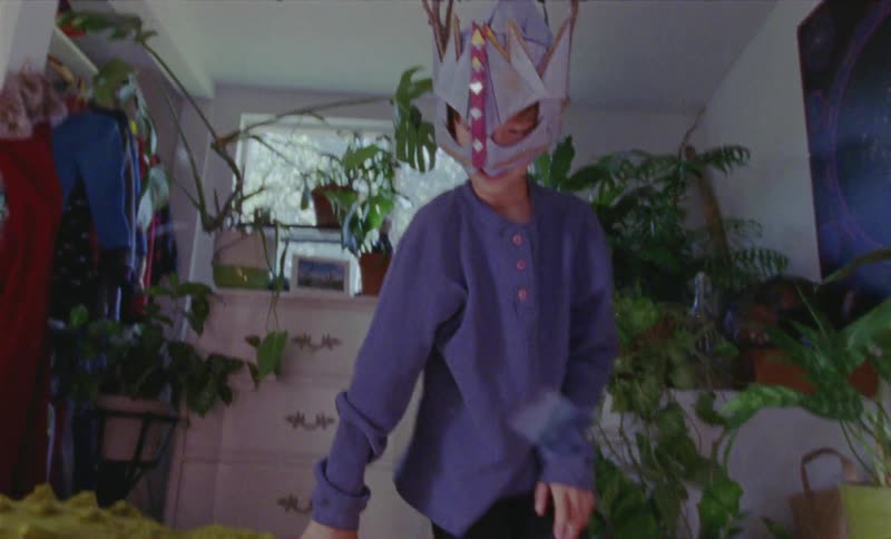 Child wearing a mask plays in a bedroom
