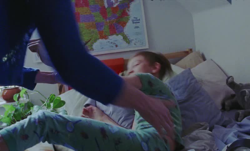 A woman plays with a child in the bed