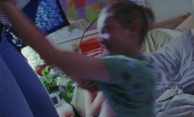 Woman plays with a child on a bed