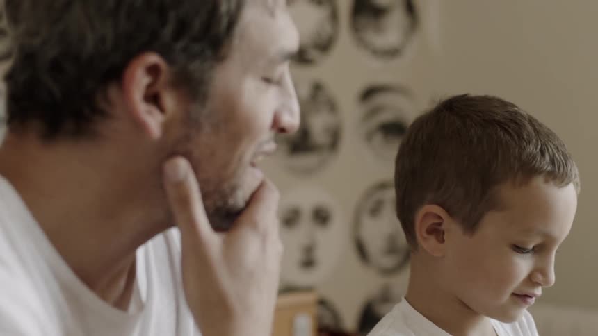 A man and child talk together at the table
