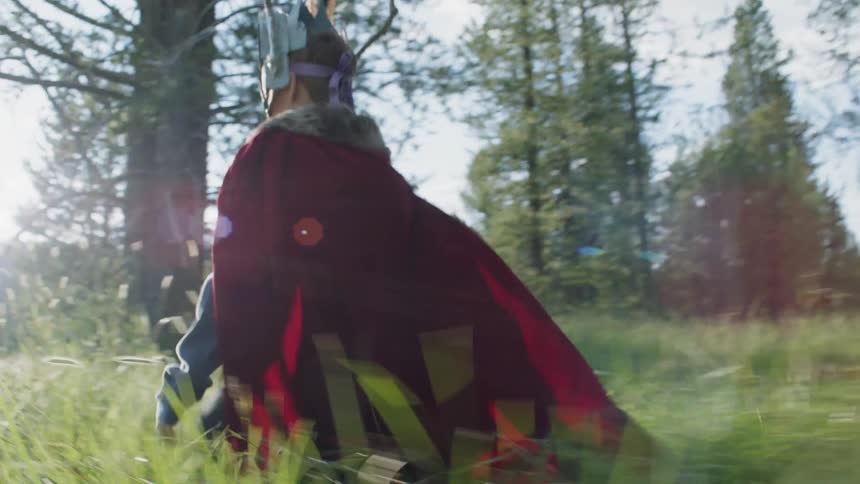 Boy in a costume runs in a forest