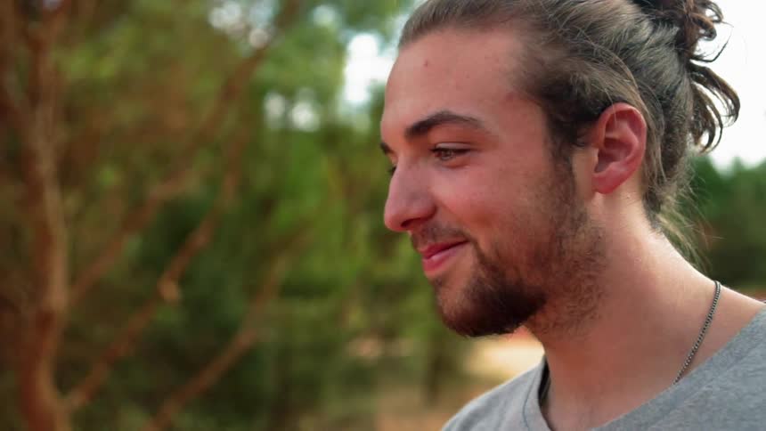 Man smiles and stands outside