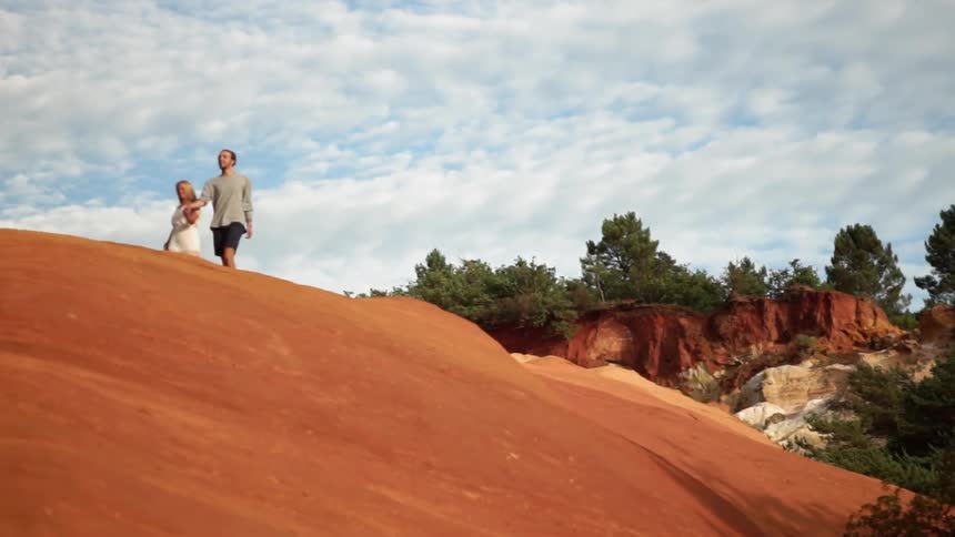 Couple walk across red dirt