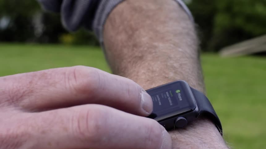 Man taps and scrolls on his watch