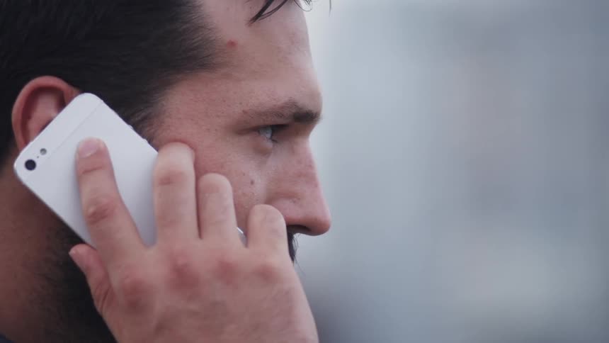 Man is talking on cell phone outside