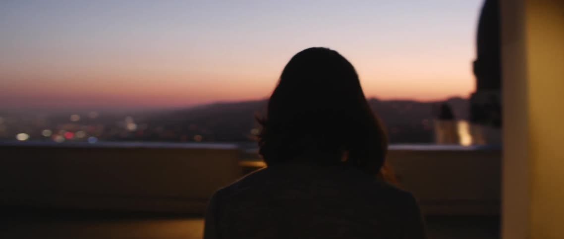 Woman walking on a rooftop at sunset