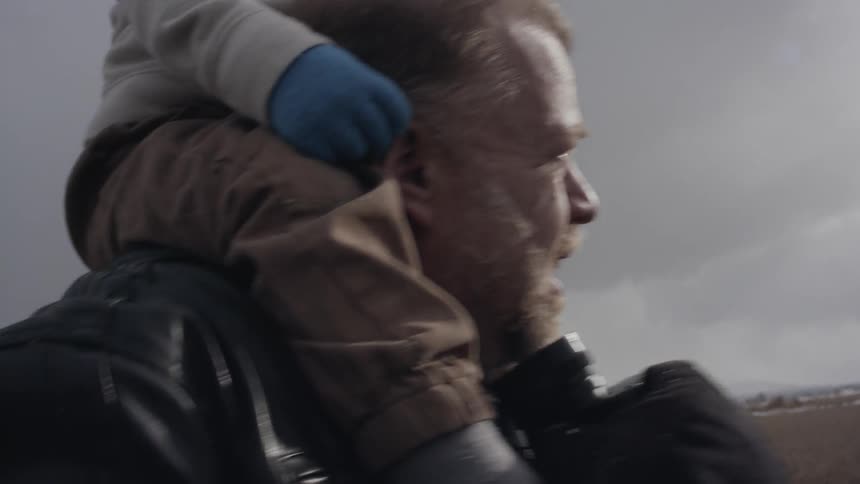 A man carries a young child on his shoulders
