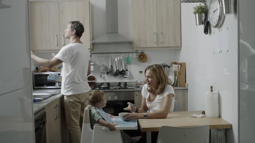 A young family is gathered in a kitchen