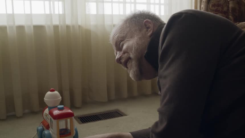 Elderly man plays with toys with a toddler