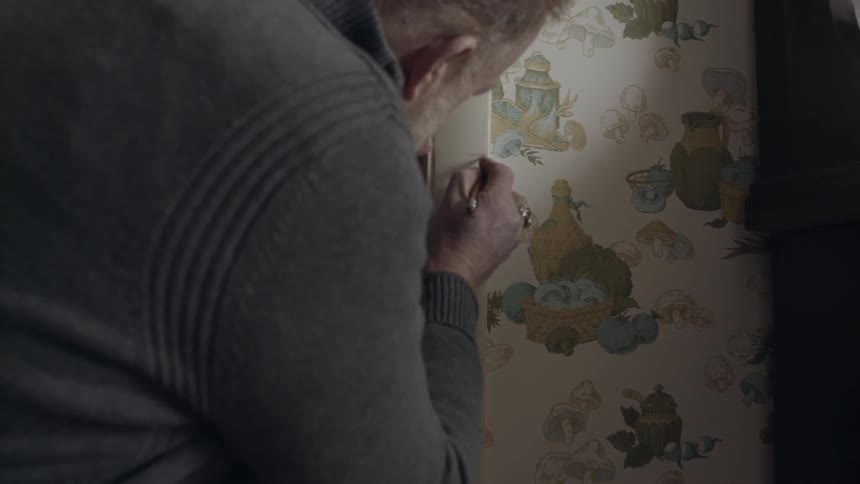 A man marks a child's height on the wall
