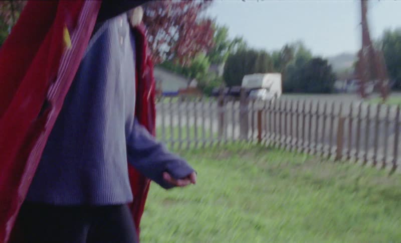 Boy is playing in front yard with stick figurine toy