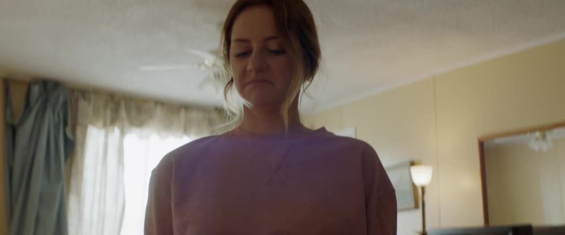 Woman picks up a glass dish and turns away