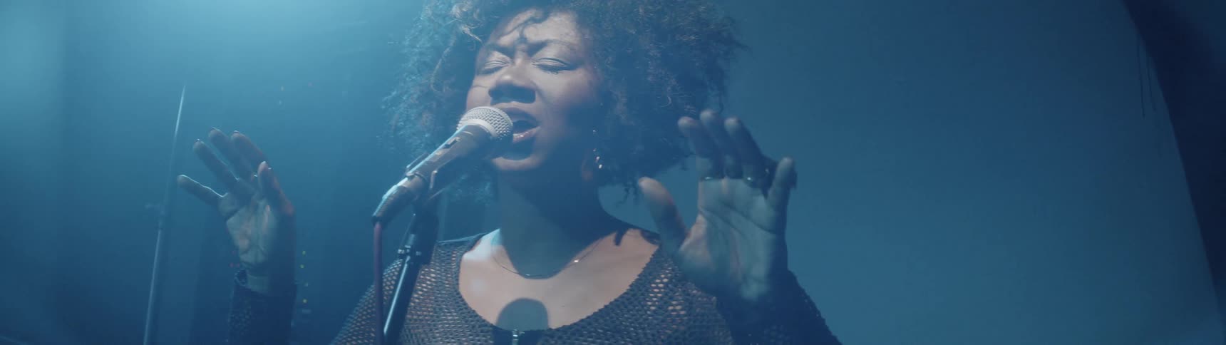 Woman is singing in front of microphone