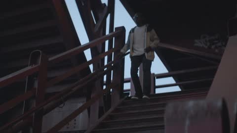 Teen boy descends an outdoor staircase