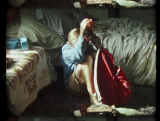 Child plays with a toy in his room hiding behind a red backpack